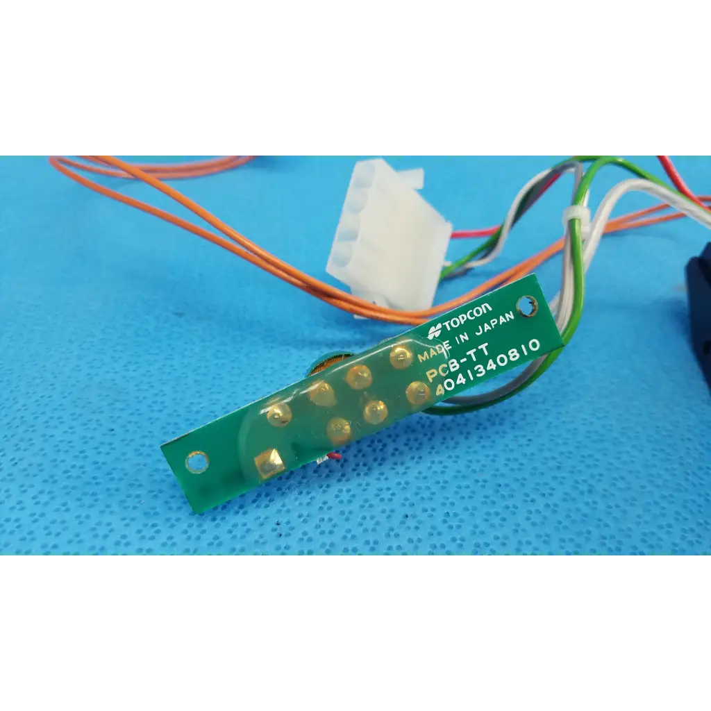 Green rectangular circuit board with gold solder points marked pcb-tt for trc-nw6s harness assembly by topcon
