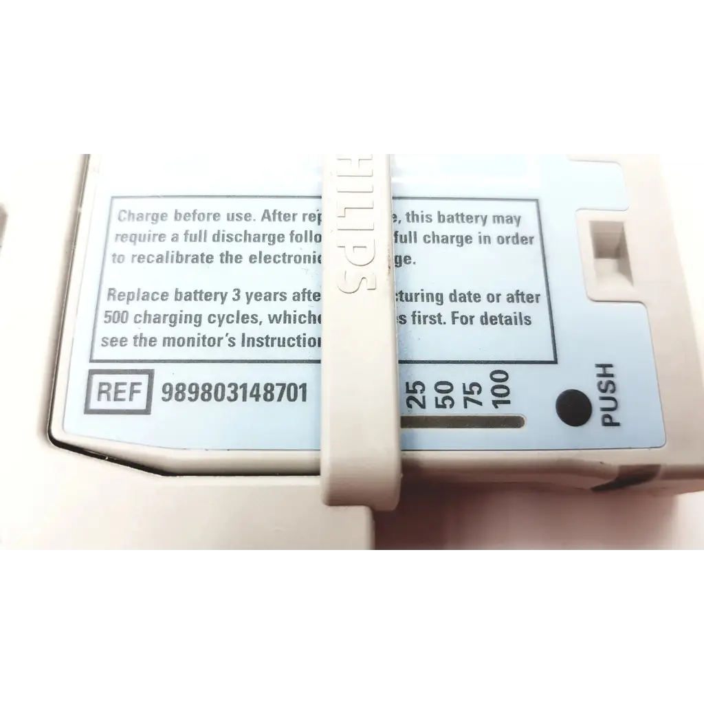 Beige philips intellivue m4607a mp2 battery module with white label showing charging instructions and push button