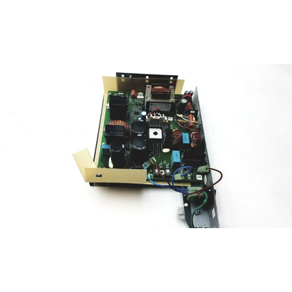 Green circuit board with black capacitors red and blue wires and metallic parts inside beige metal casing of planmeca intra psu2
