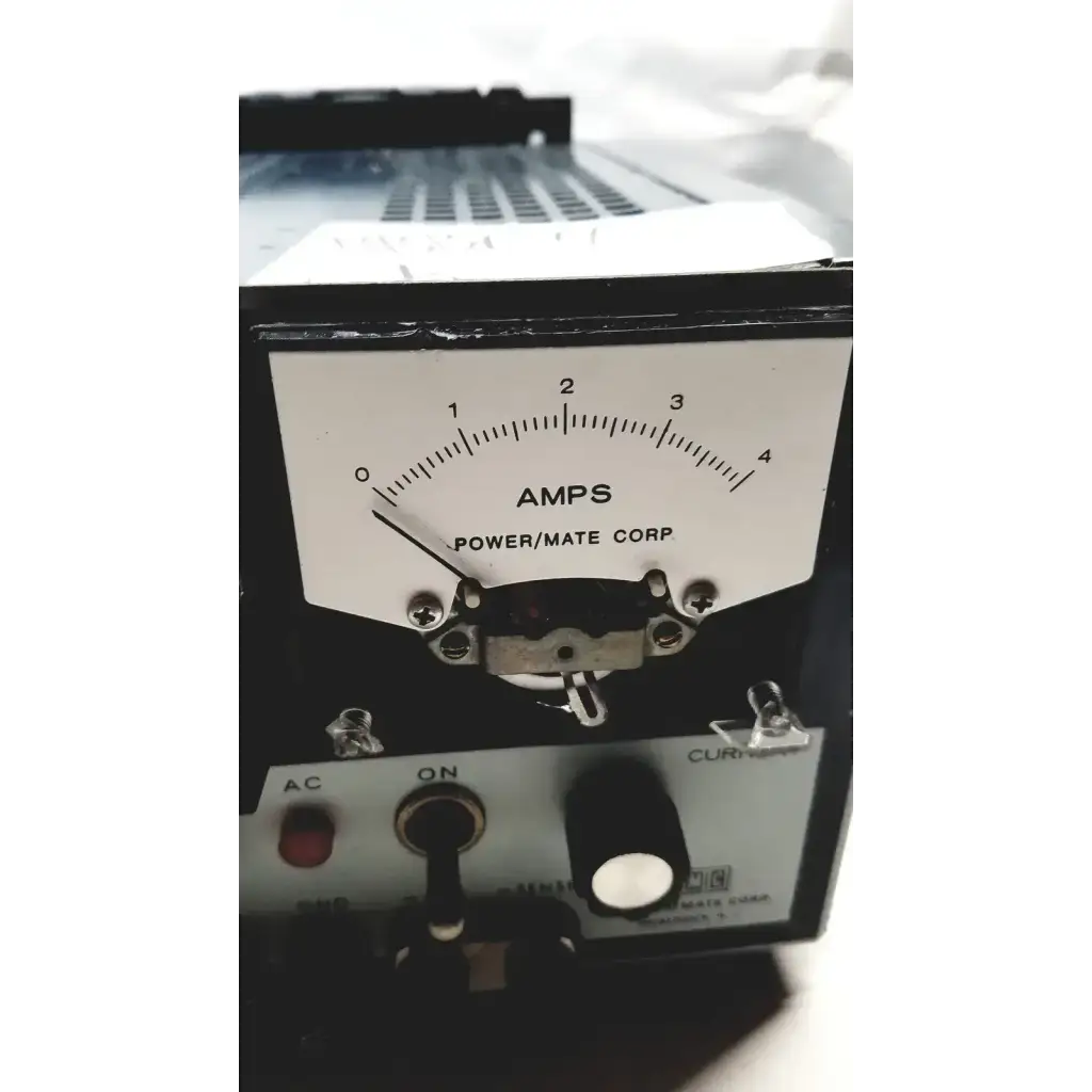 Black rectangular analog ammeter with white dial marked amps by power mate corp on metal chassis for 105-125v power supply