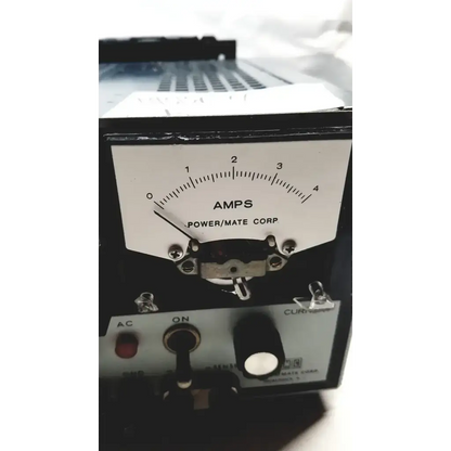 Black rectangular analog ammeter with white dial marked amps by power mate corp on metal chassis for 105-125v power supply