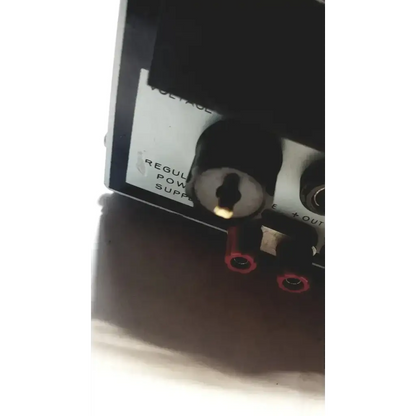 Black power supply unit with silver keyhole and red terminal connectors by power mate corp for 105-125v use