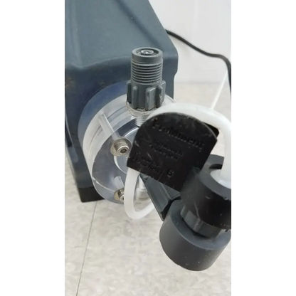 Black plastic ProMinent Gamma X GMXA 1009 diaphragm metering pump with transparent chamber and white tubing connected