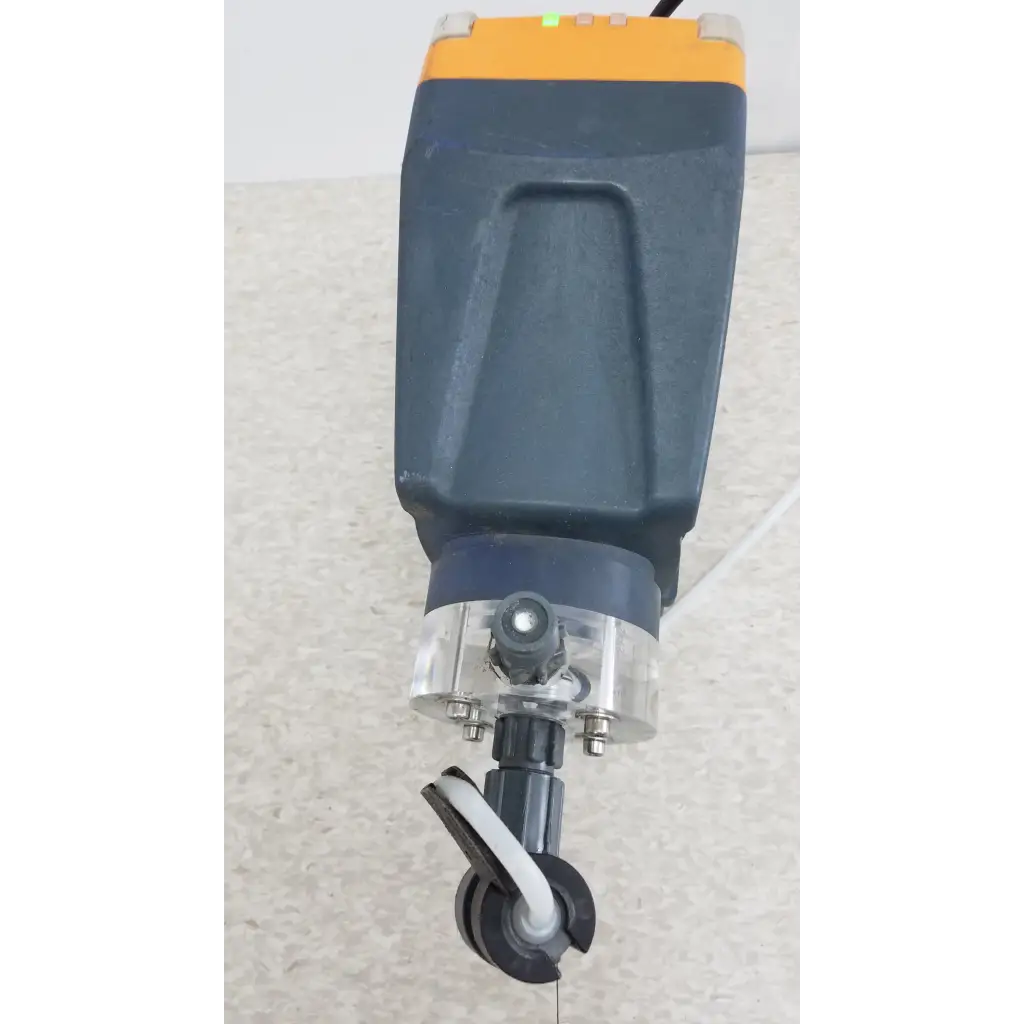 Industrial-grade laser cutter with dark gray and orange housing and transparent cover shown with prominent gamma x gmxa 1009 diaphragm metering pump