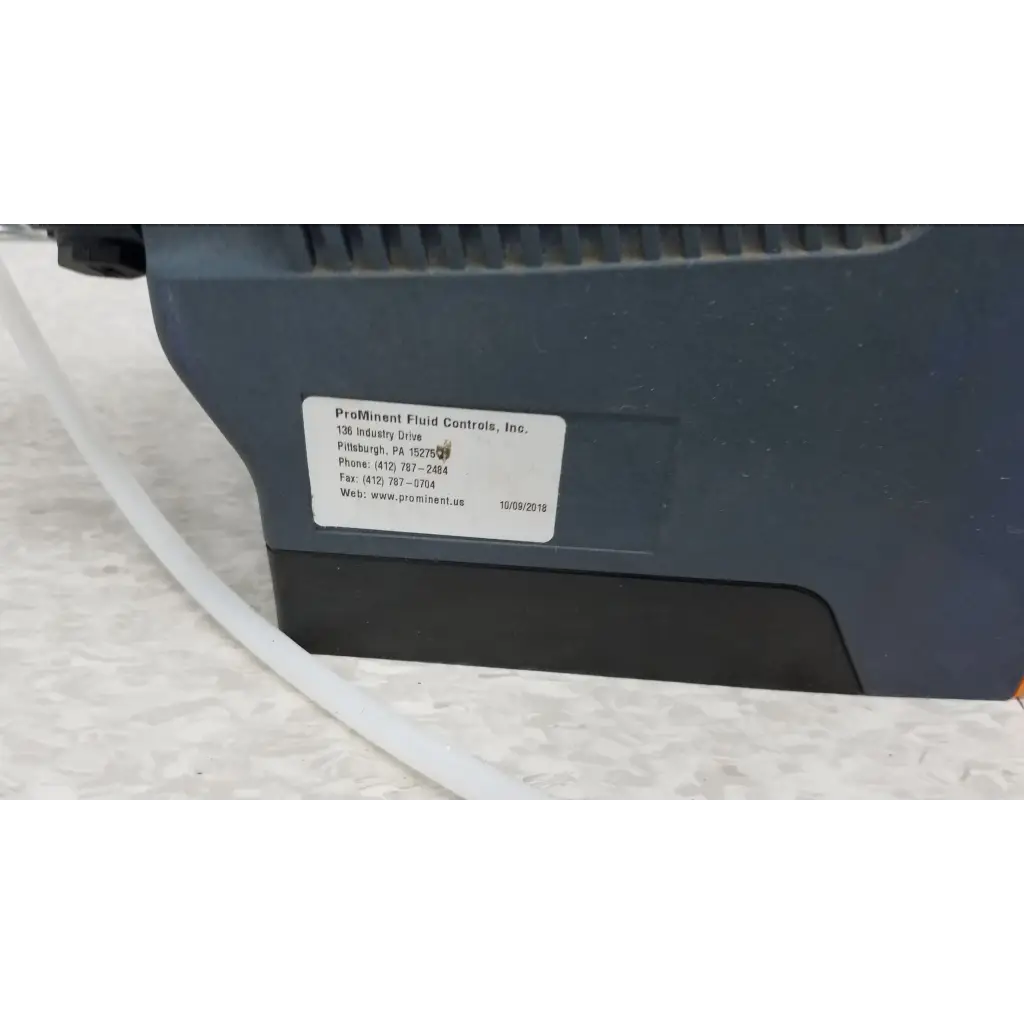 Dark gray industrial diaphragm metering pump with white label showing company contact for prominent gamma x gmxa 1009