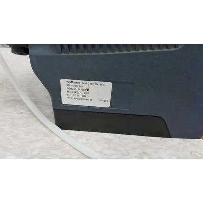 Dark gray industrial diaphragm metering pump with white label showing company contact for prominent gamma x gmxa 1009