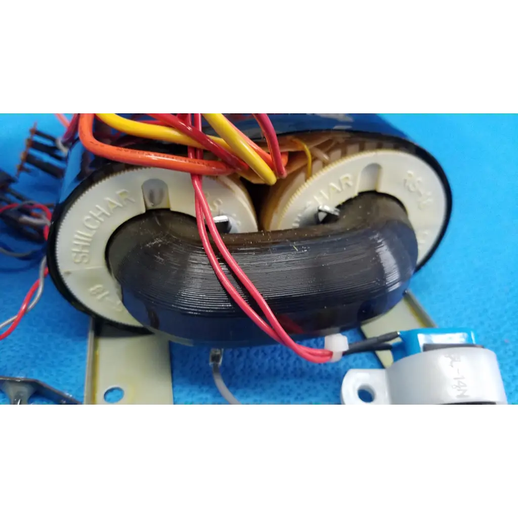 Black cylindrical core power transformer with white end caps and red yellow orange wires for retinal camera use