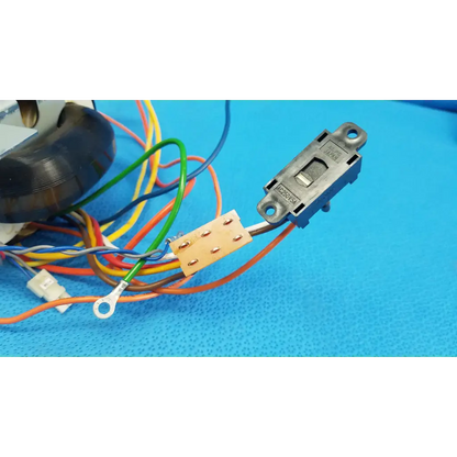 Black plastic toggle switch with metallic contacts and multicolored wires for core power transformer in retinal camera
