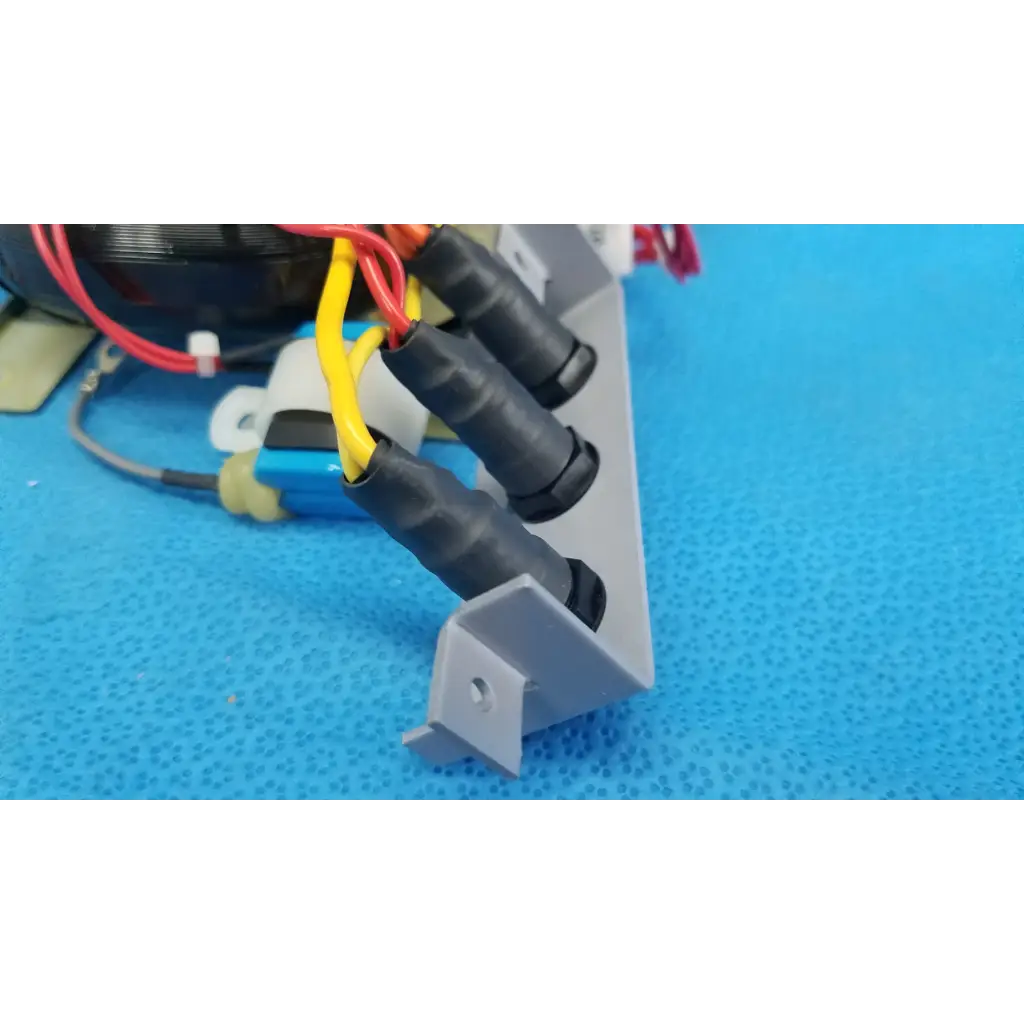 Gray plastic mounting bracket with black insulated wire connectors holding red and yellow wires for topcon retinal camera core power transformer