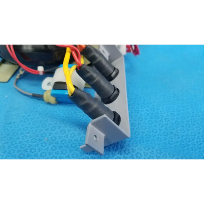 Gray plastic mounting bracket with black insulated wire connectors holding red and yellow wires for topcon retinal camera core power transformer