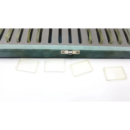 Teal velvet case with silver clasp holding four clear glass slides in resonance technology set optical lenses