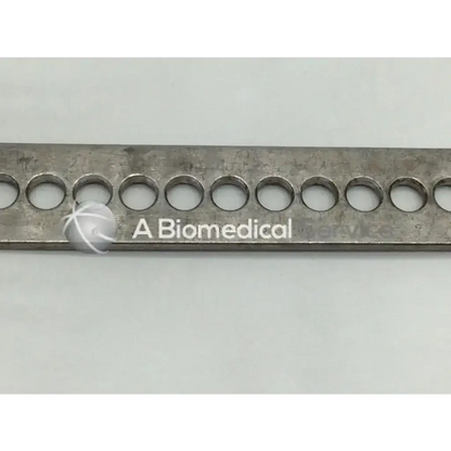 A metallic rectangular plate with circular holes featuring a biomedical logo for nephew deep blades self-retaining retractor