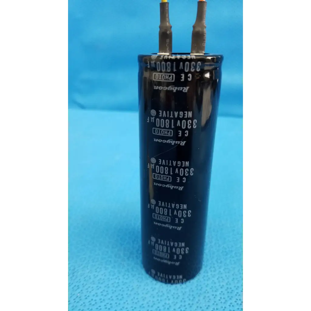 Black cylindrical rubycon photo capacitor 330v 1800uf with silver lettering and two metallic terminals for trc-nw6s retinal camera