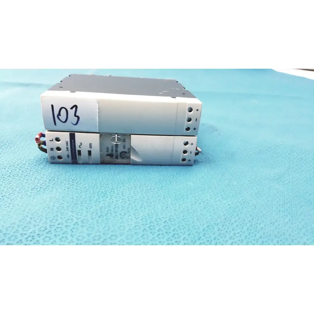 Silver industrial switch mode din rail panel mount power supply stacked with one labeled 103 schneider electric abl7 rp1205