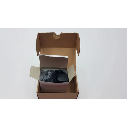 Black seca medical power supply adapter with coiled cord in plastic wrap inside a cardboard box for medical power supply