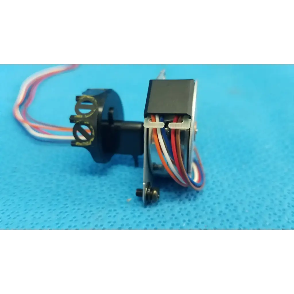 Black plastic Seiko Epson internal shutter stepper motor with multi-colored wiring and metallic gear housing for Topcon retinal camera