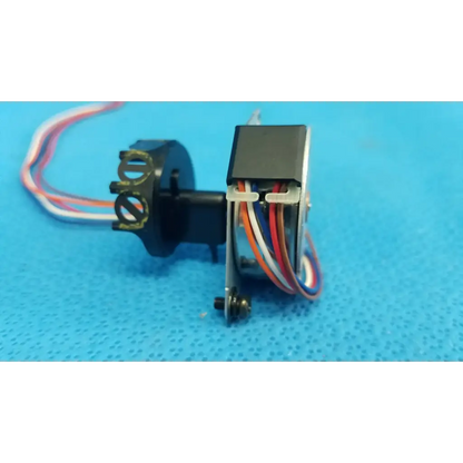 Black plastic Seiko Epson internal shutter stepper motor with multi-colored wiring and metallic gear housing for Topcon retinal camera
