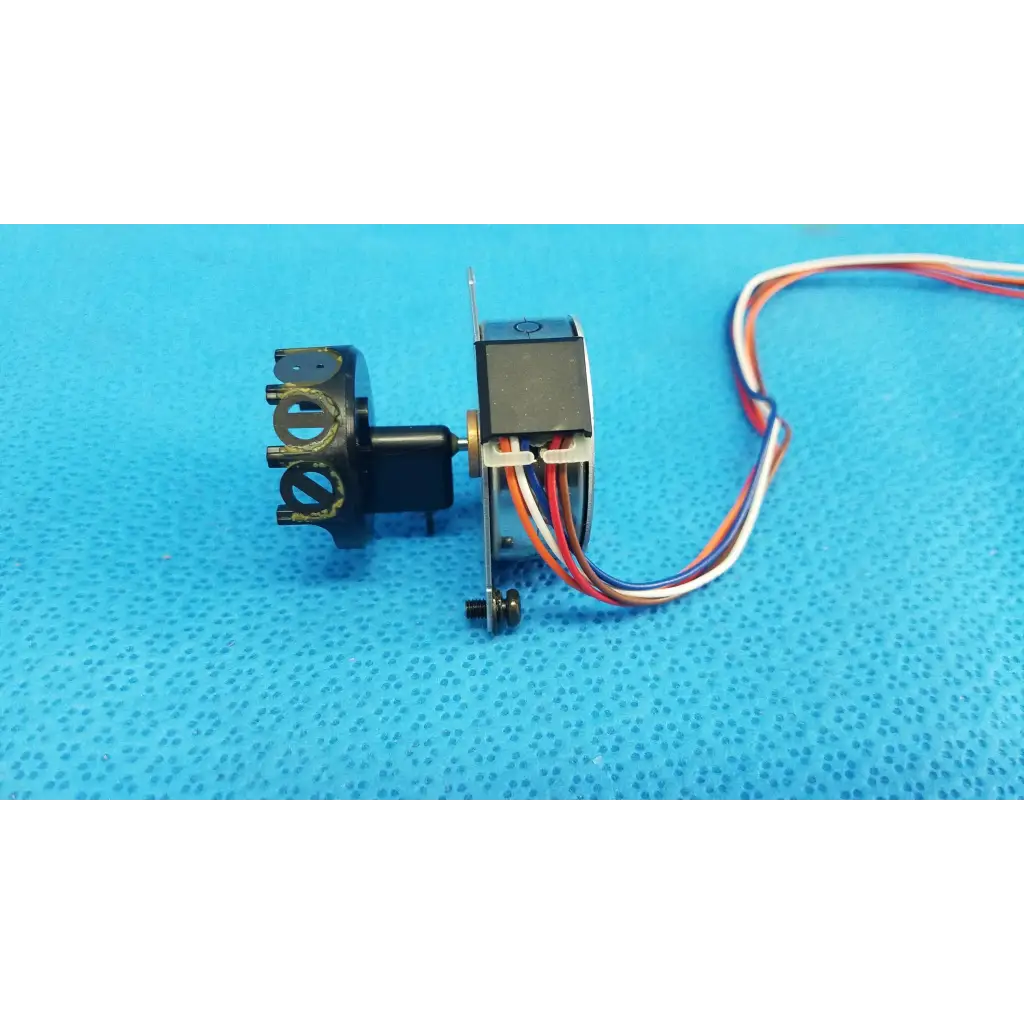 Black seiko epson stepper motor with multi-colored wiring and metallic parts for internal shutter in retinal camera