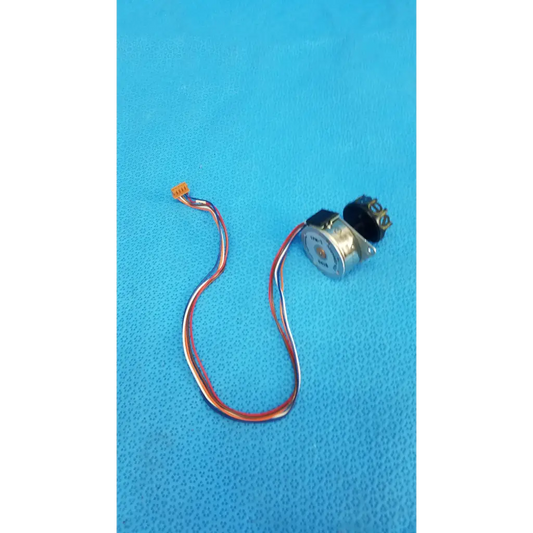 Silver-colored internal shutter stepper motor with black gear housing and red white blue wires for retinal camera
