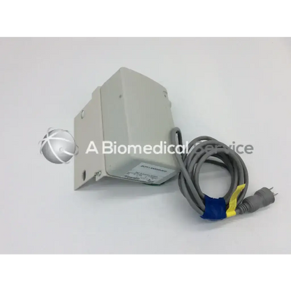 Gray rectangular skf actuation system bcu53-2n3100-0000 medical device with coiled power cord secured by blue and yellow ties
