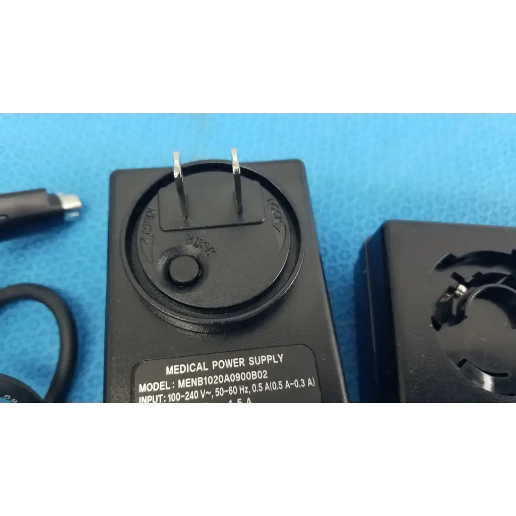 Black plastic medical power supply menb1020a0900b02 with two prongs and circular dial for medical equipment use