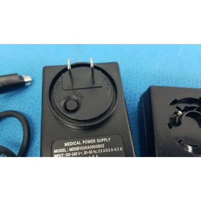 Black plastic medical power supply menb1020a0900b02 with two prongs and circular dial for medical equipment use