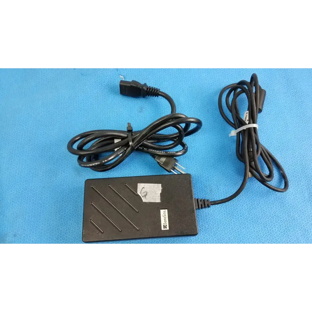 Black plastic sonosite ultrasound power supply po8792-02 with coiled cables and white label for medical use