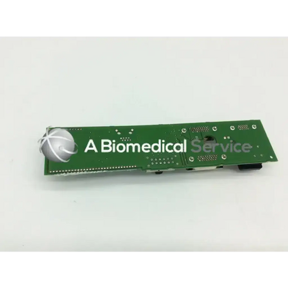 Green rectangular circuit board with silver spherical component and white text for Spacelabs 670-1298-00 Rev E monitor parts
