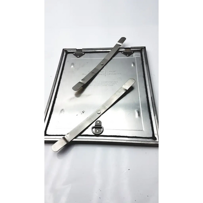 Silver metallic square manhole cover with two lifting bars on top for spectroline 10x12 radiographic cassette use