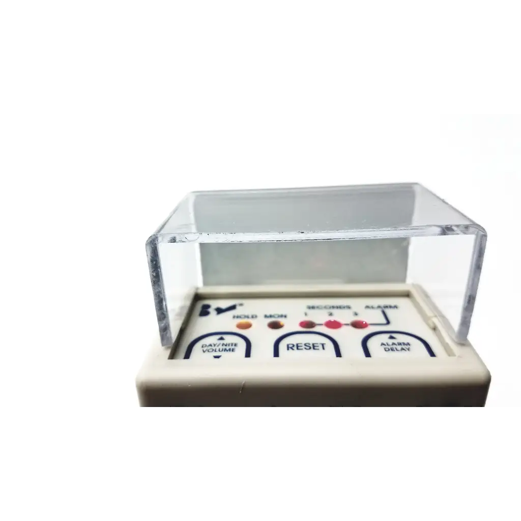 White plastic digital alarm clock with clear cover and labeled buttons for alarm delay and volume in stanley classic-check bed check fall risk monitoring