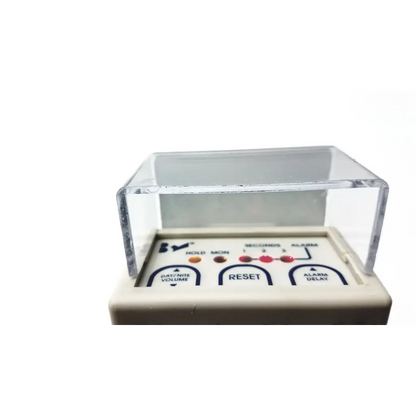 White plastic digital alarm clock with clear cover and labeled buttons for alarm delay and volume in stanley classic-check bed check fall risk monitoring