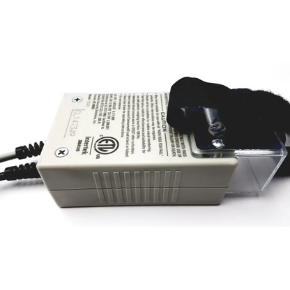 Beige plastic power adapter with black cables and clear protective cover shown on the back side of stanley classic-check bed check for fall risk monitoring