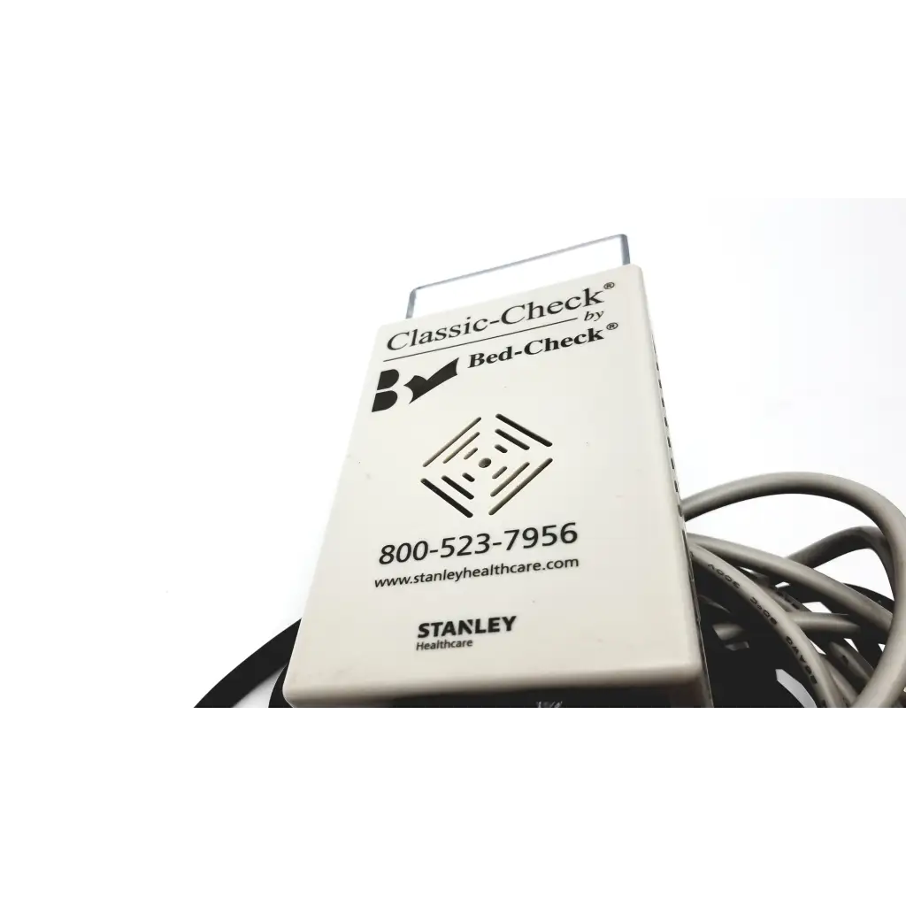 White rectangular Stanley Classic-Check bed check device with metallic handle and coiled cable for fall risk monitoring