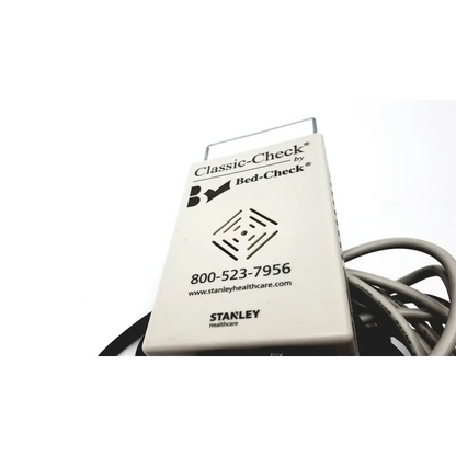White rectangular Stanley Classic-Check bed check device with metallic handle and coiled cable for fall risk monitoring