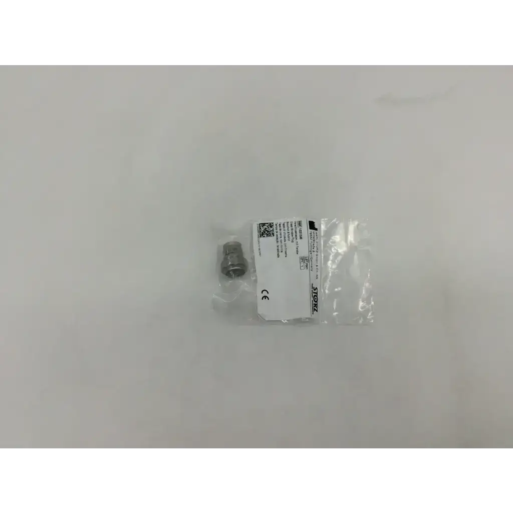A small metallic storz 10315m glass window plug packaged in clear plastic with a white treos label