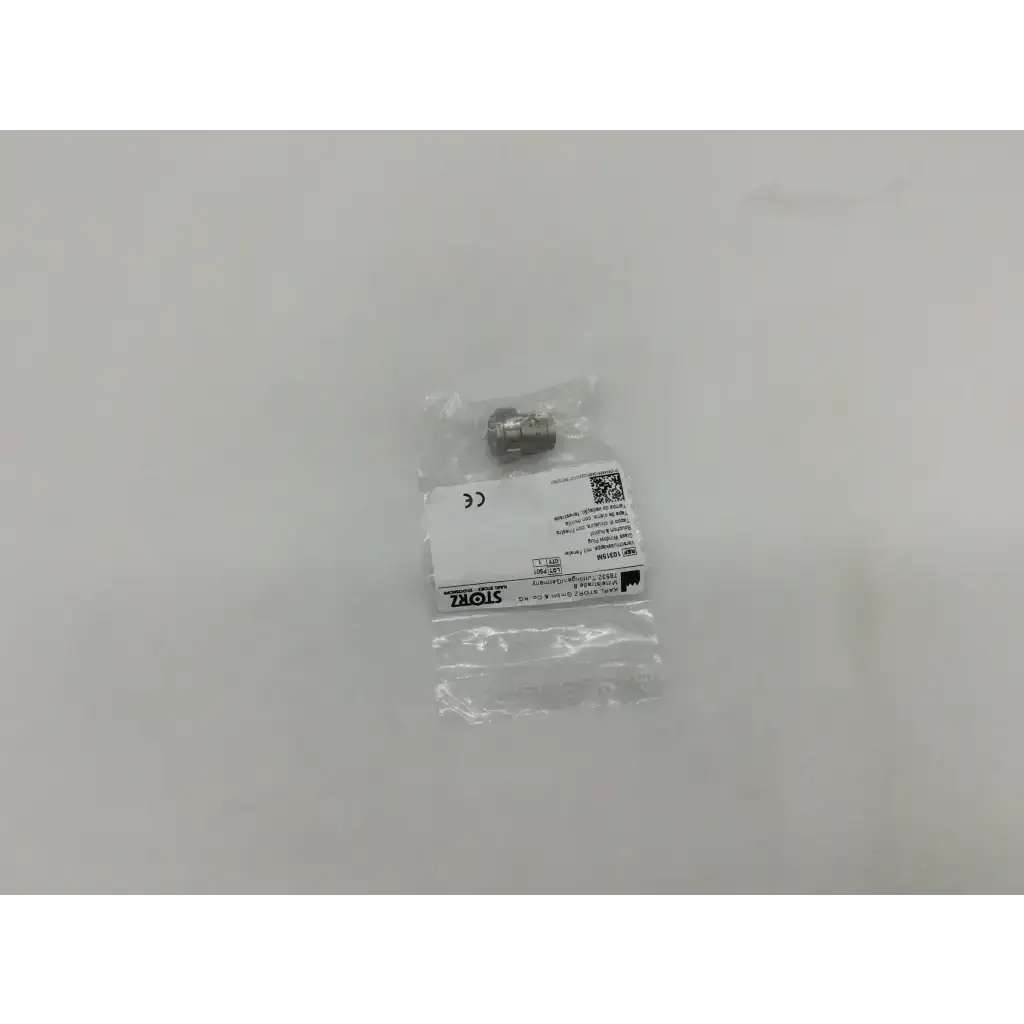 A metallic storz 10315m glass window plug with a threaded cylindrical body and hexagonal head in clear plastic packaging