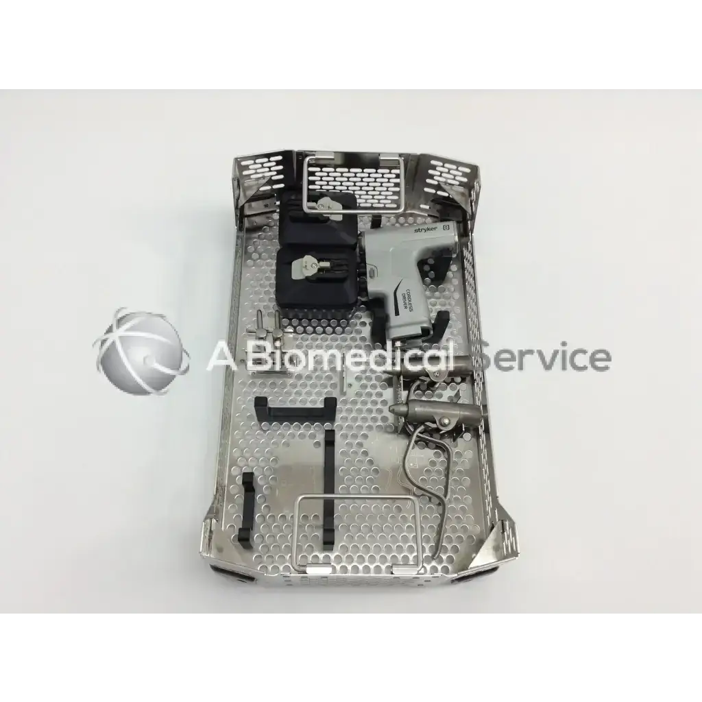 Silver perforated metal surgical tray holding gray and black stryker 4505 cordless driver set with aesculap case