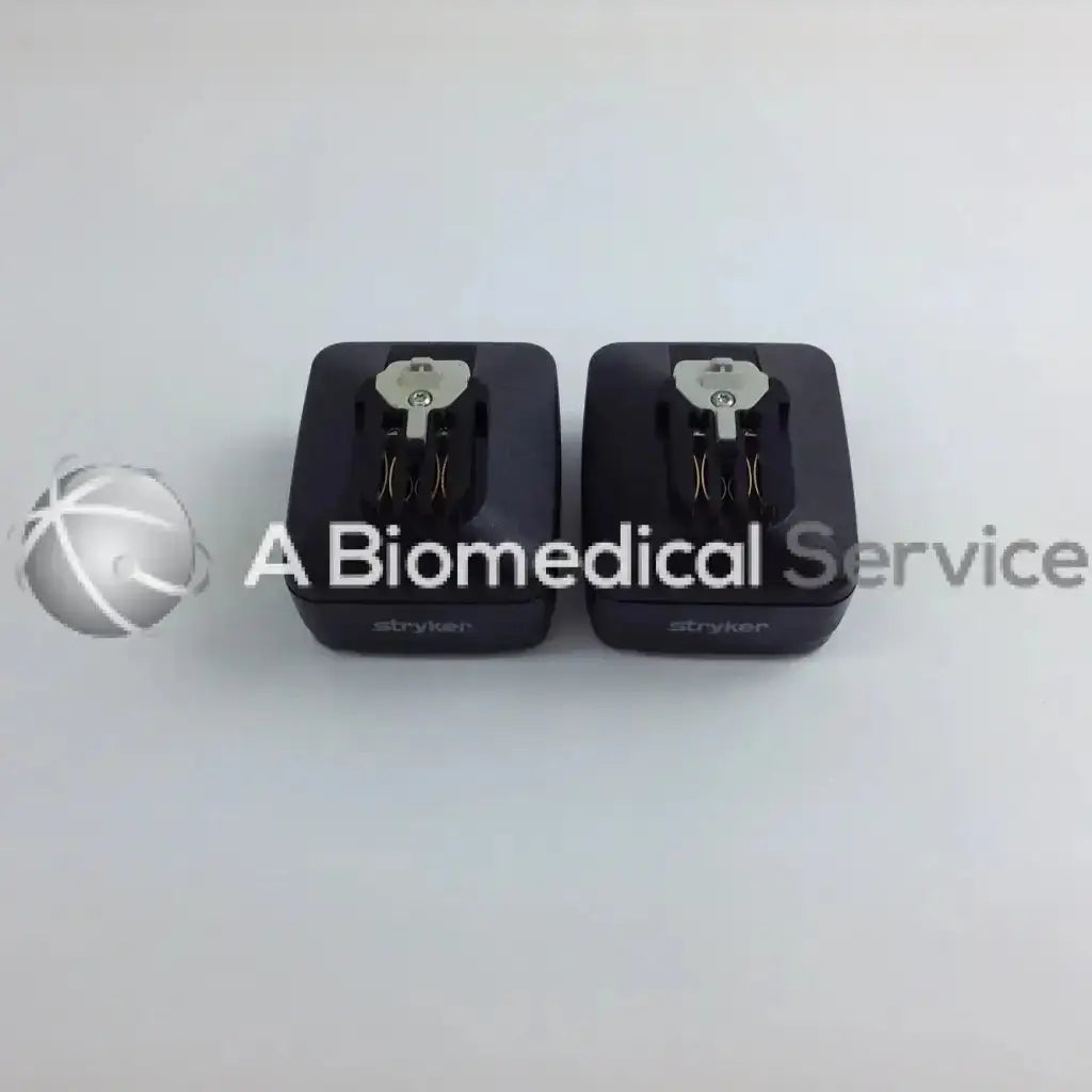 Two black stryker cordless driver chargers with silver keyhole tops in aesculap case for driver set use