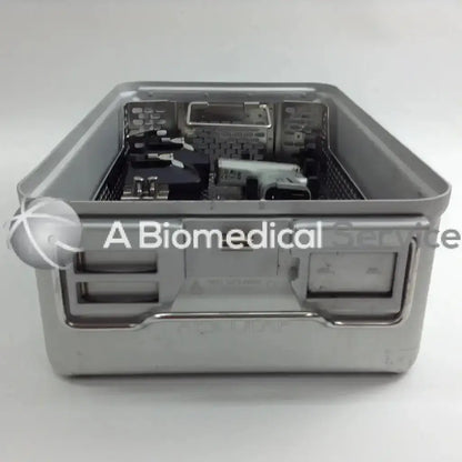 Gray stainless steel surgical instrument tray with molded handles and mesh interior for organizing tools in aesculap case