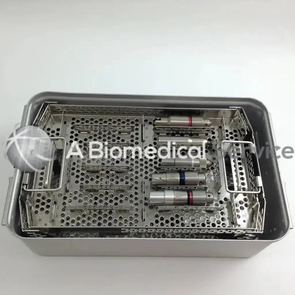 Stainless steel surgical instrument tray with perforated compartments holding medical tools in aesculap case of stryker cordless driver set