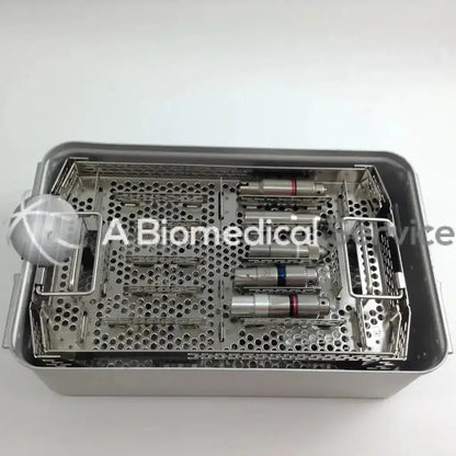 Stainless steel surgical instrument tray with perforated compartments holding medical tools in aesculap case of stryker cordless driver set