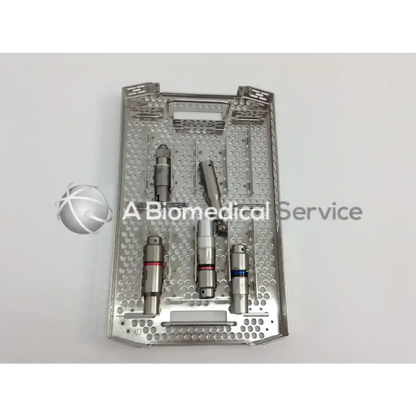Silver perforated surgical tray with precision drills and cannulas holding stryker 4505 cordless driver set aesculap case