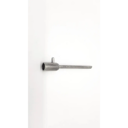 Silver metallic stryker fits tan pipe with cylindrical head and threaded shaft featuring engraved text along its length