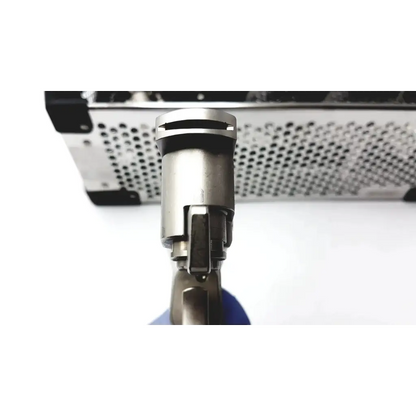 Silver metallic cylindrical nozzle of stryker system 7 large bone battery powered drill with perforated metal housing background