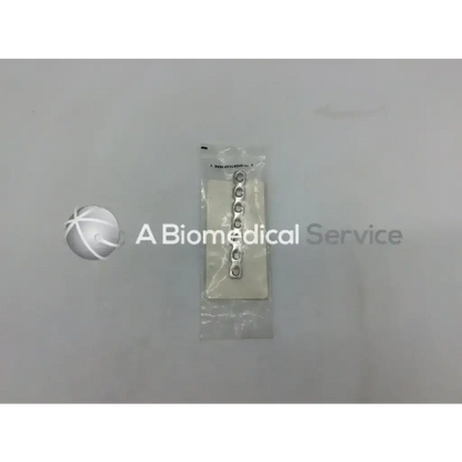 Silver-colored Synthes 3.5mm reconstruction plate with 7 holes 82mm packaged in clear plastic for surgical use