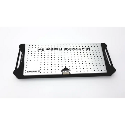 Silver perforated metal plate with black handles labeled synthes mini external fixation set for orthopedic use