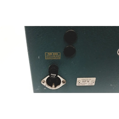 Dark green metal electrical panel with black fuse cover and voltage labels on the back of tektronix storage oscilloscope 3a1 dual trace