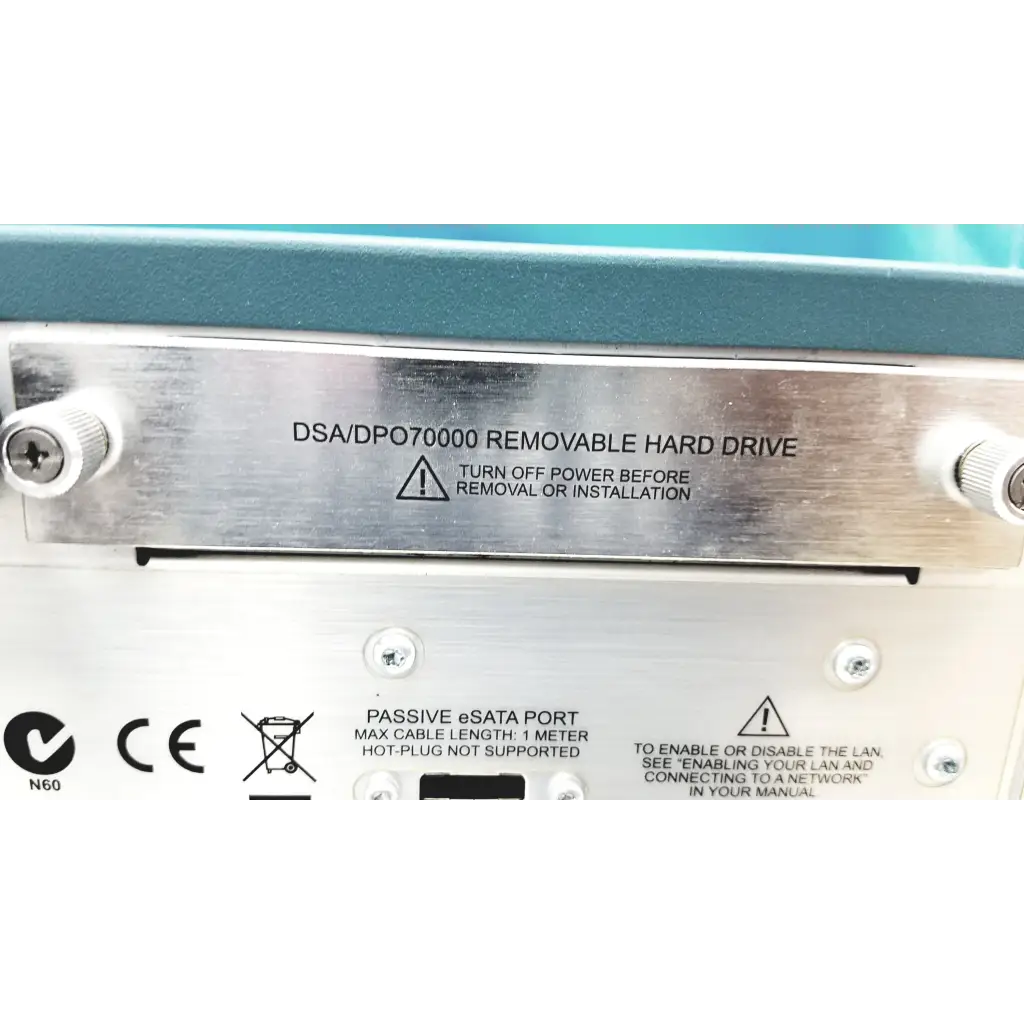 Silver metallic label with engraved text and warning symbols on the removable hard drive of tektronix awg7122c arbitrary waveform generator