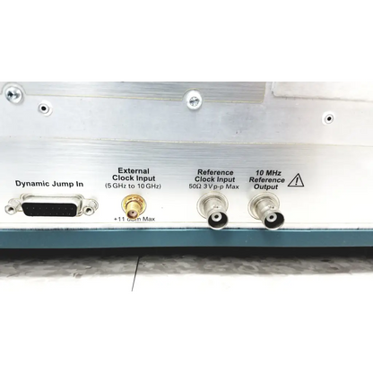 Silver electronic test equipment panel with d-sub, gold coaxial, and bnc connectors on the back of tektronix awg7122c arbitrary waveform generator