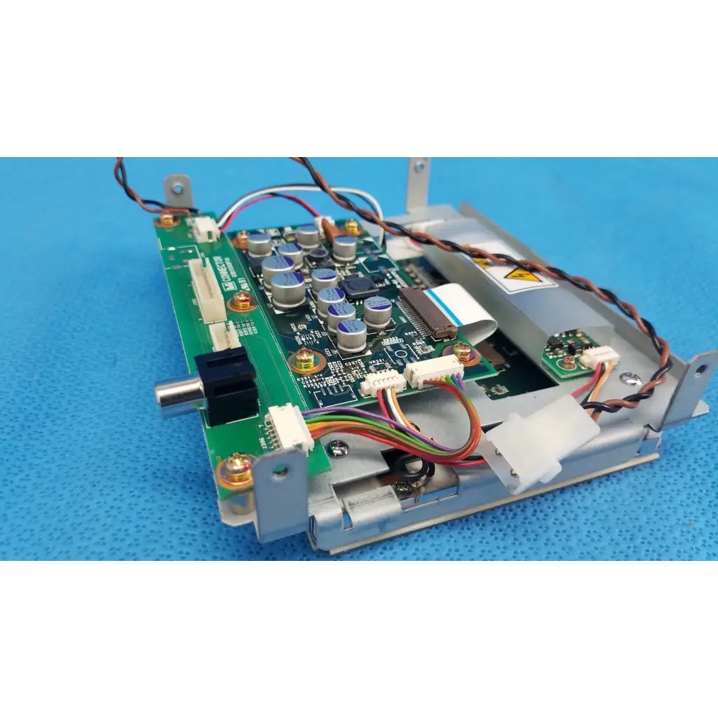 Green printed circuit board with silver capacitors and multicolored wiring in gray plastic casing for lcd monitor control